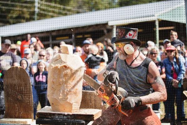 a man carving a log with a chainsaw