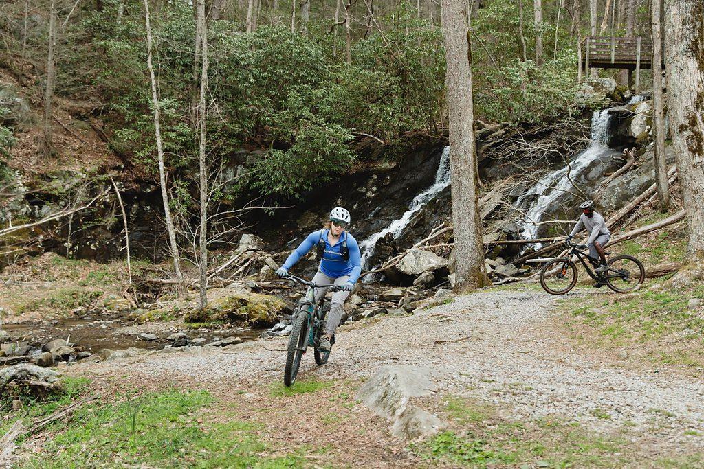 mountain biking by a waterfall