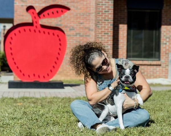 a woman and her dog sitting in the grass