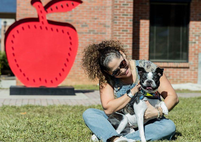 a woman and her dog sitting in the grass