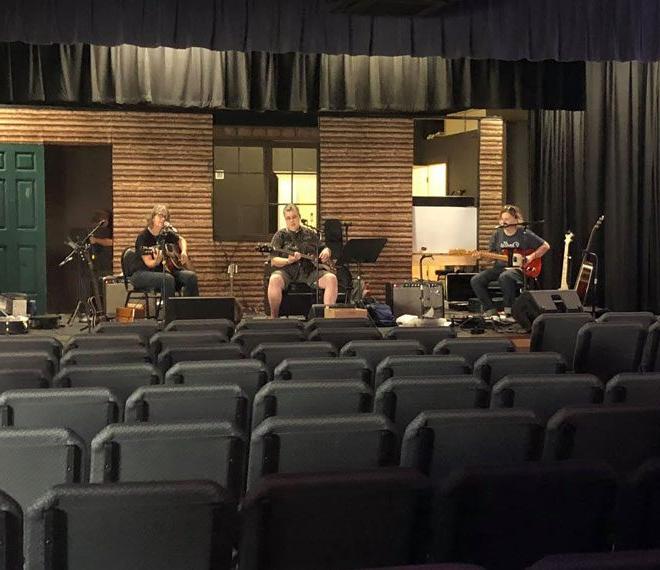 a band playing on stage at the Gilmer Arts Playhouse